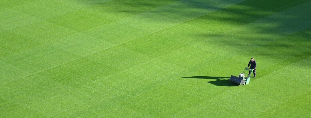 A man mowing the lawn with a big mowing machine